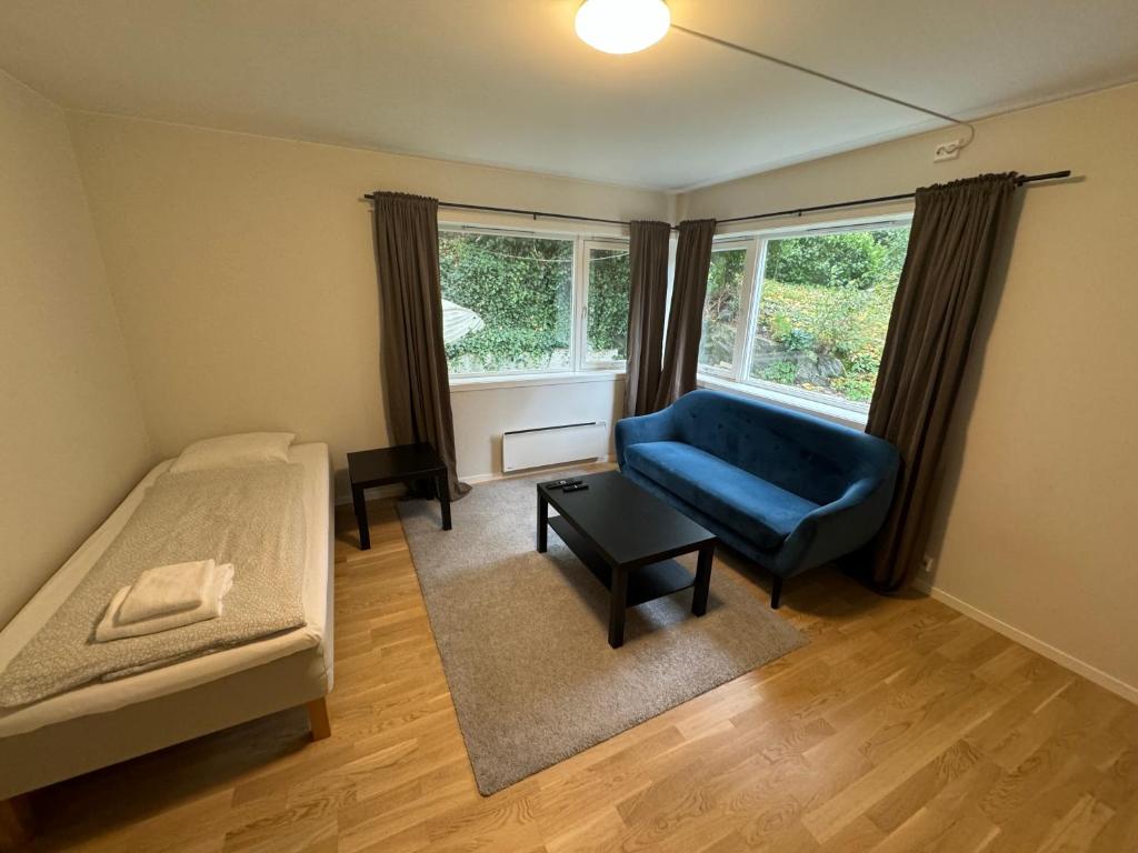 Un dormitorio con una cama y un sofá azul y una ventana. en City Apartments - Stavanger, en Stavanger