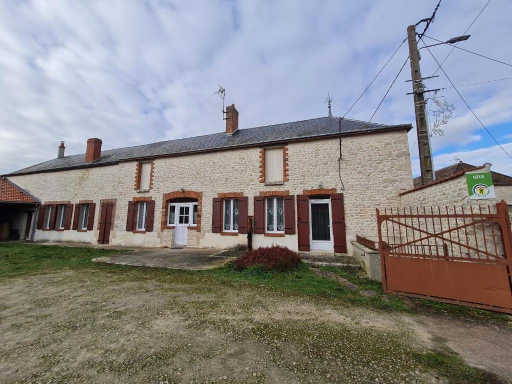 an old brick house with a gate in front of it at Charmante Longère Gâtinaise - Cour et Jardin Clos, Proche Paris et Orléans - FR-1-590-73 in Sceaux-du-Gâtinais