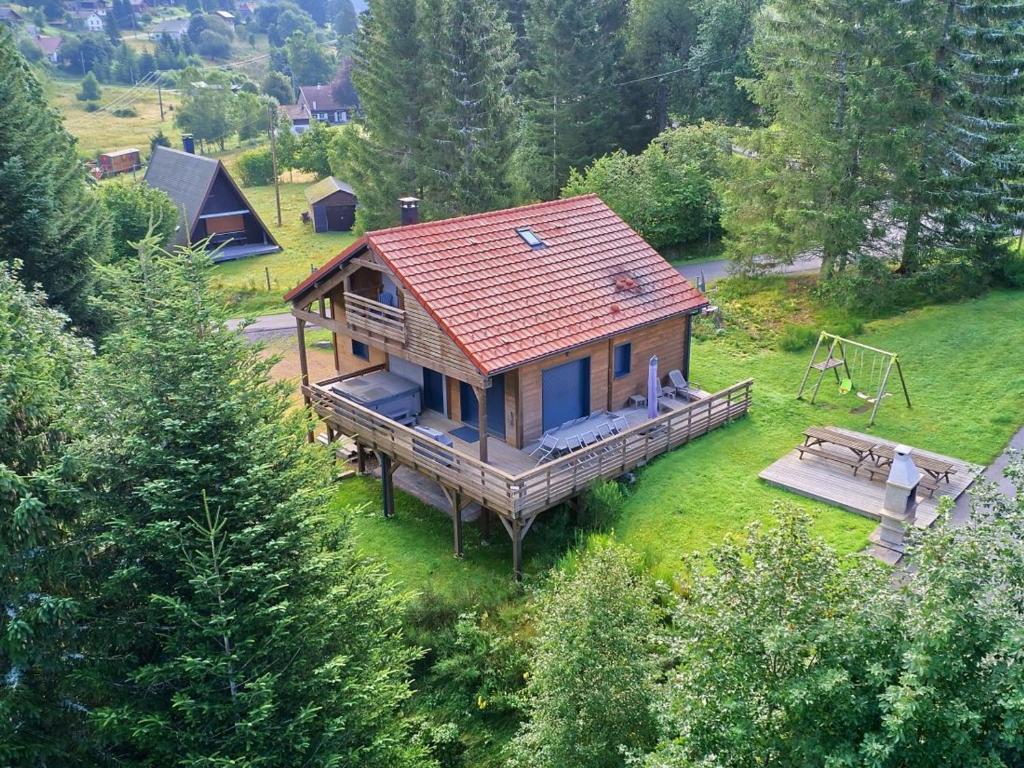 Draufsicht auf ein Blockhaus mit Spielplatz in der Unterkunft Chalet familial confortable avec spa, proche Gérardmer et station de ski, idéal été et hiver. - FR-1-589-469 in Ban-sur-Meurthe-Clefcy