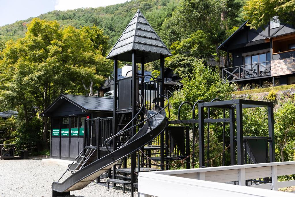 a playground with a slide in front of a building at Kawaguchiko Country Cottage Ban in Fujikawaguchiko
