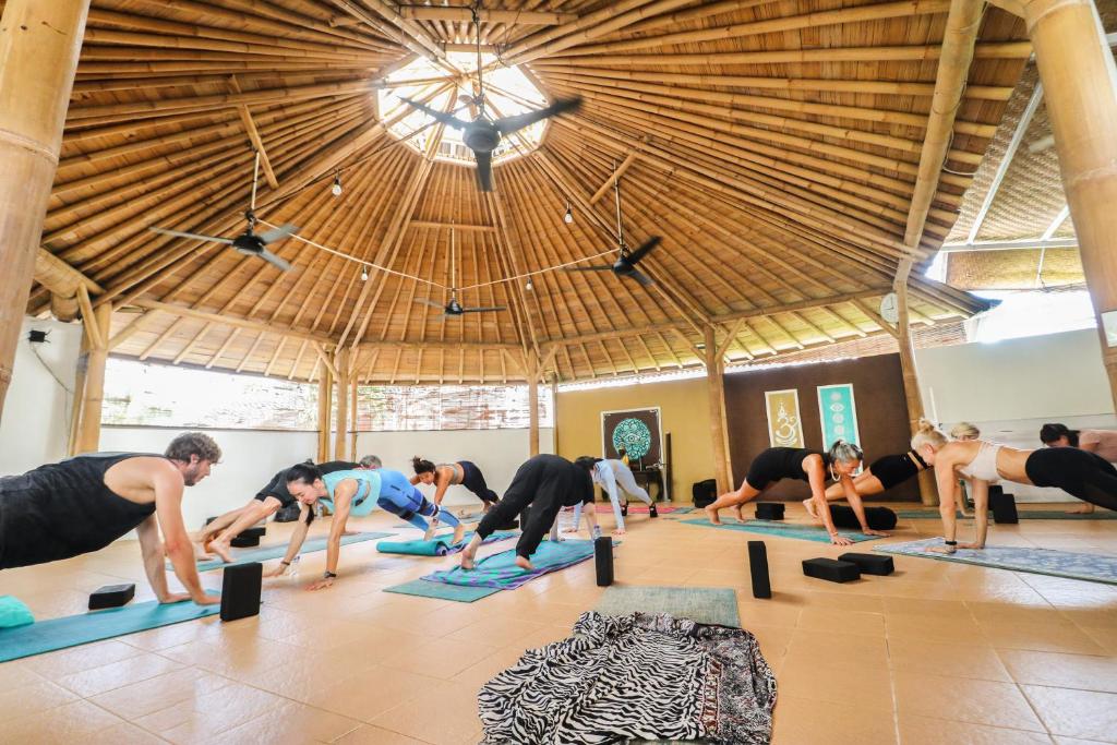- un groupe de personnes faisant du yoga dans une salle de sport dans l'établissement Serenity Eco Guesthouse - CHSE certified, à Canggu