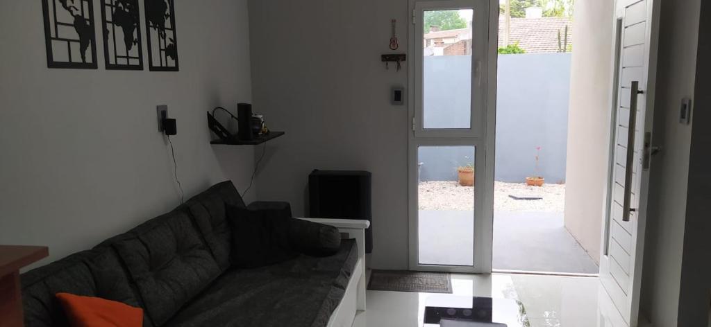 Casa la florida في مار ديل بلاتا: غرفة معيشة مع أريكة وباب مفتوح