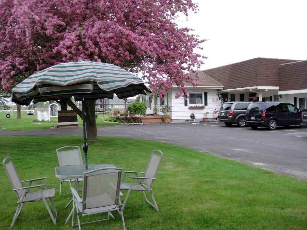 a table and chairs and an umbrella in a yard at Country Squire Motel in Arnprior