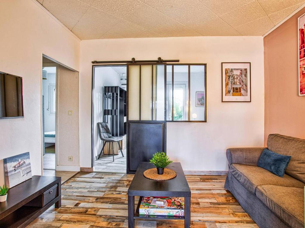 un salon avec un canapé et une table dans l'établissement Maison de plain-pied avec jardin privé et terrasse à Cabourg - FR-1-788-40, à Cabourg