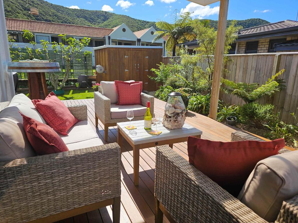 a patio with wicker furniture and a table and chairs at Private Hideaway with Beach & Marina Access in Waikawa
