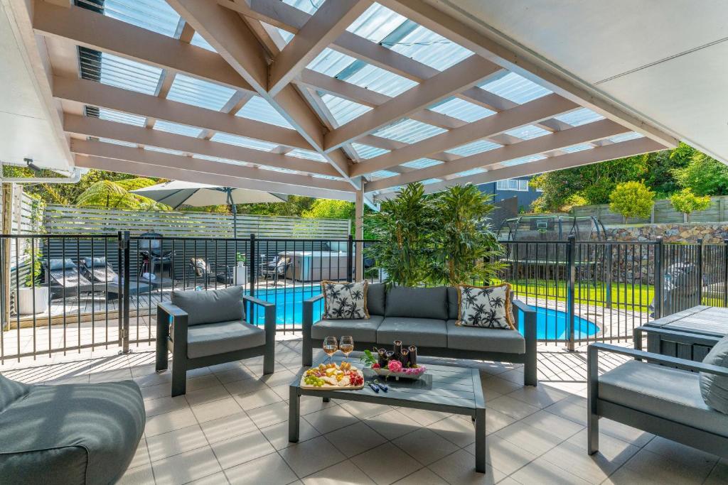 a patio with couches and a table with a table at Tuis and Pools - Lake Taupo Holiday Home in Taupo