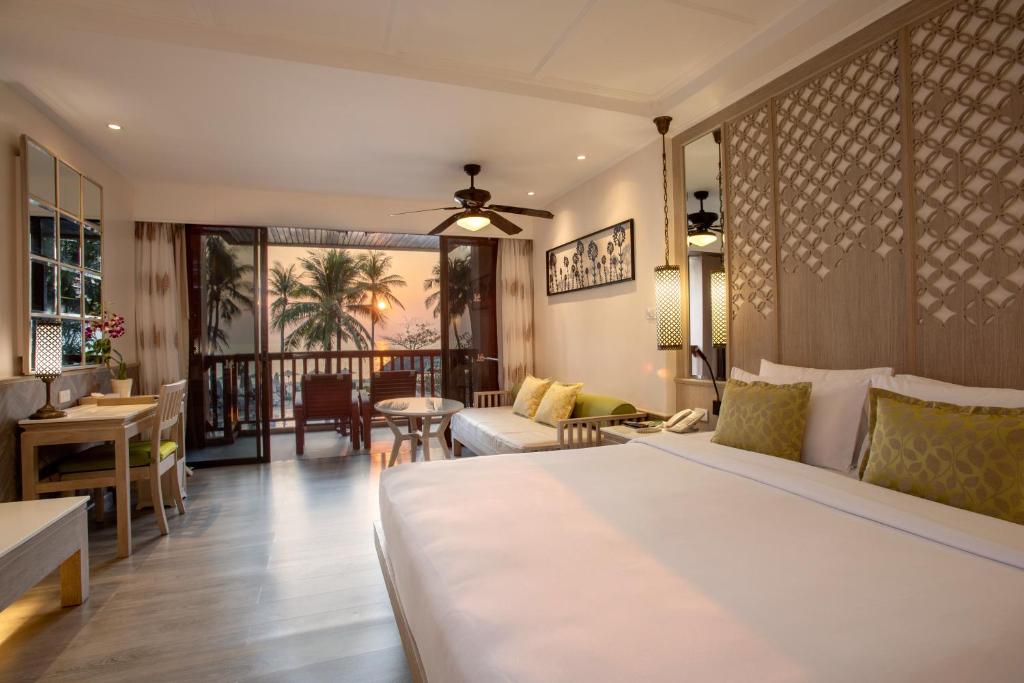 a bedroom with a bed and a living room at Katathani Phuket Beach Resort - SHA Extra Plus in Kata Beach