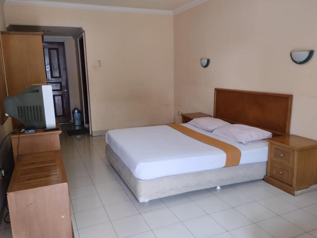 Postel nebo postele na pokoji v ubytování HOTEL & WISMA BINTANG JADAYAT