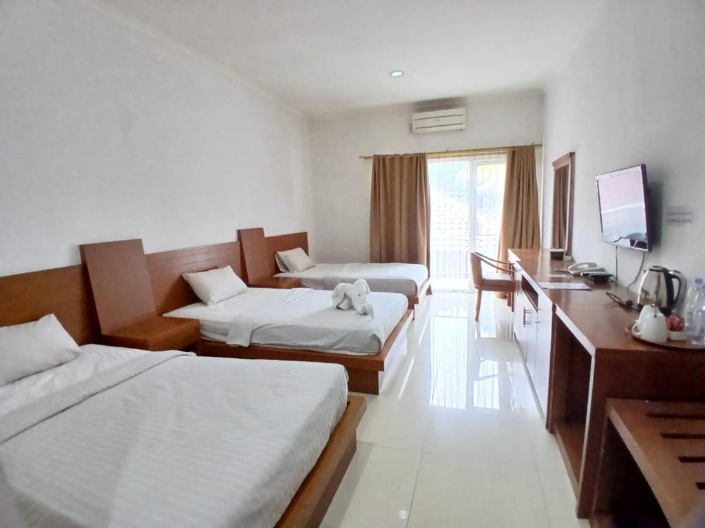 Postel nebo postele na pokoji v ubytování HOTEL & WISMA BINTANG JADAYAT