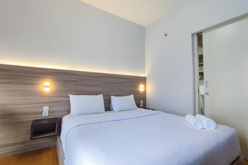 Ένα ή περισσότερα κρεβάτια σε δωμάτιο στο Comfort 1BR at Amartha View Apartment By Travelio
