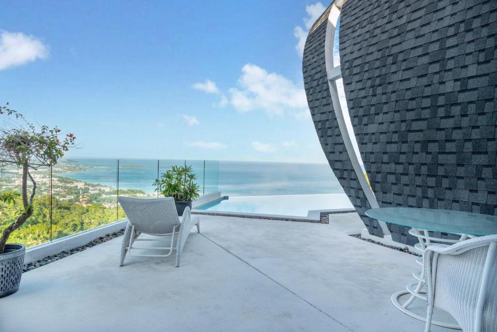 a balcony with a table and chairs and the ocean at Seaview Dreamscape Villa in Amphoe Koh Samui