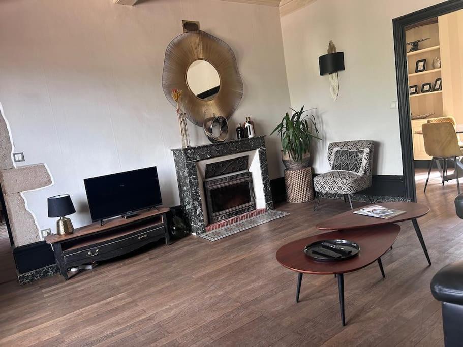 イジェにあるLa Tour Mailly - 3 pièces tout confortの暖炉とテレビのあるリビングルーム