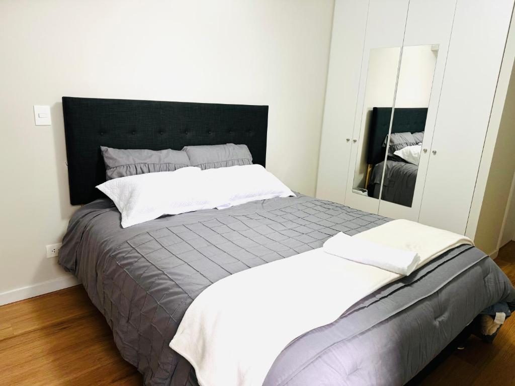 ein Schlafzimmer mit einem großen Bett und einem Spiegel in der Unterkunft Alojamiento Mama Ocllo in Lima