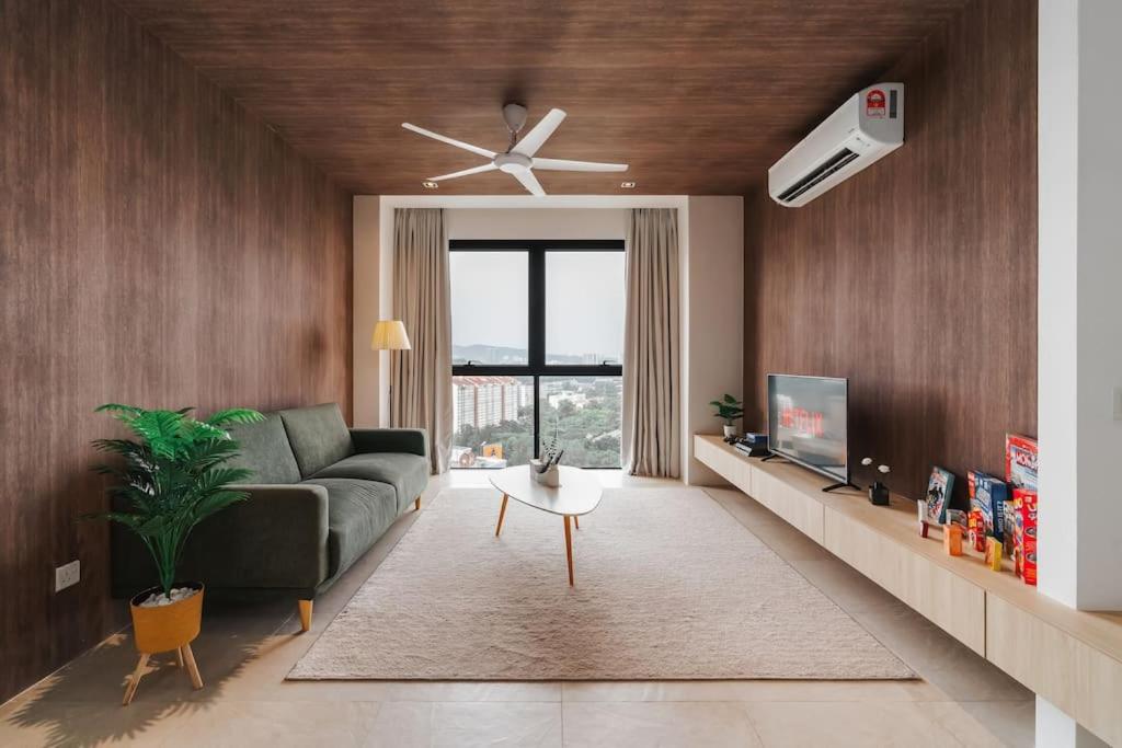 a living room with a couch and a ceiling fan at Lumi Tropicana Muji in Petaling Jaya