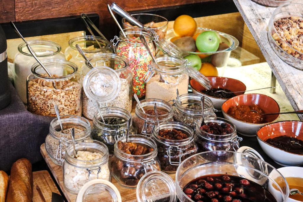 a table with many jars of food and other foods at Amsterdam Hotel in Belgrade