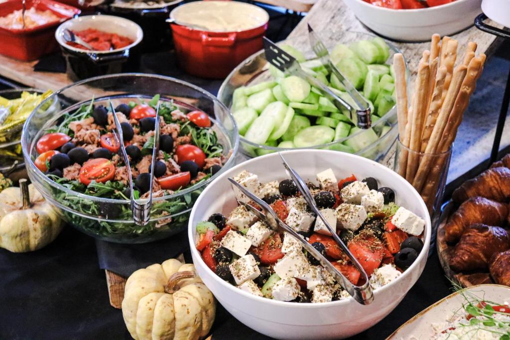 a table topped with bowls of food and vegetables at Amsterdam Hotel in Belgrade