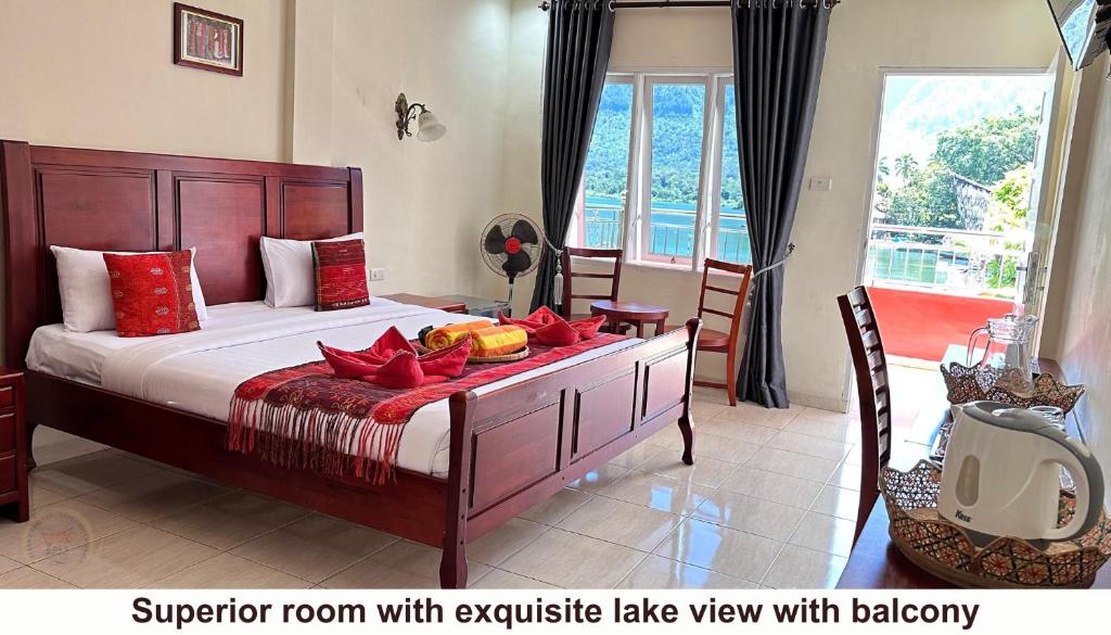 a bedroom with a large bed with a room with a balcony at Zoé’s Paradise Waterfront Hotel in Tuktuk Siadong