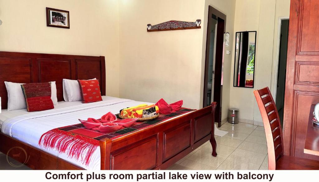 a bedroom with a bed with red flowers on it at Zoé’s Paradise Waterfront Hotel in Tuktuk Siadong