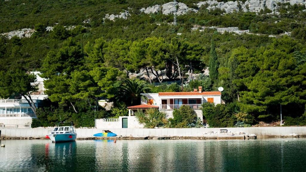 uma casa na costa de um corpo de água em Holiday Home Gluscevic em Klek