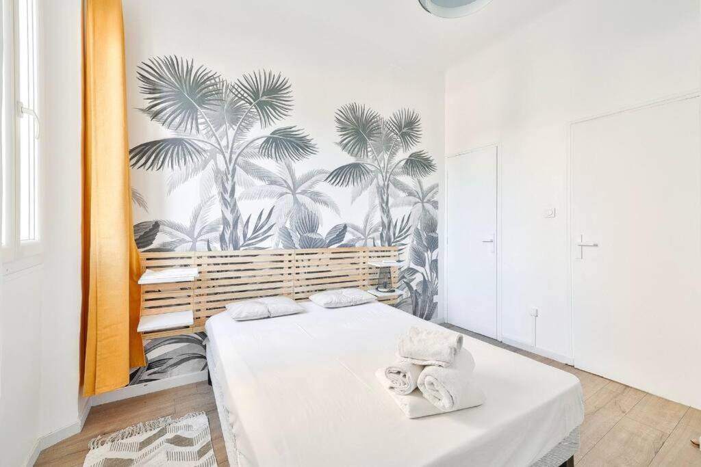 - une chambre avec un lit recouvert de palmiers dans l'établissement Élégant appartement - centre Prado Vélodrome, à Marseille