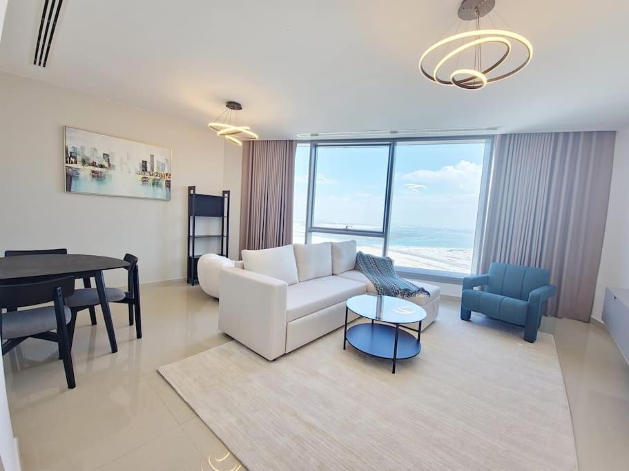 a living room with a white couch and a table at HARF5110-Luxury 1BR w pool & GYM in Abu Dhabi