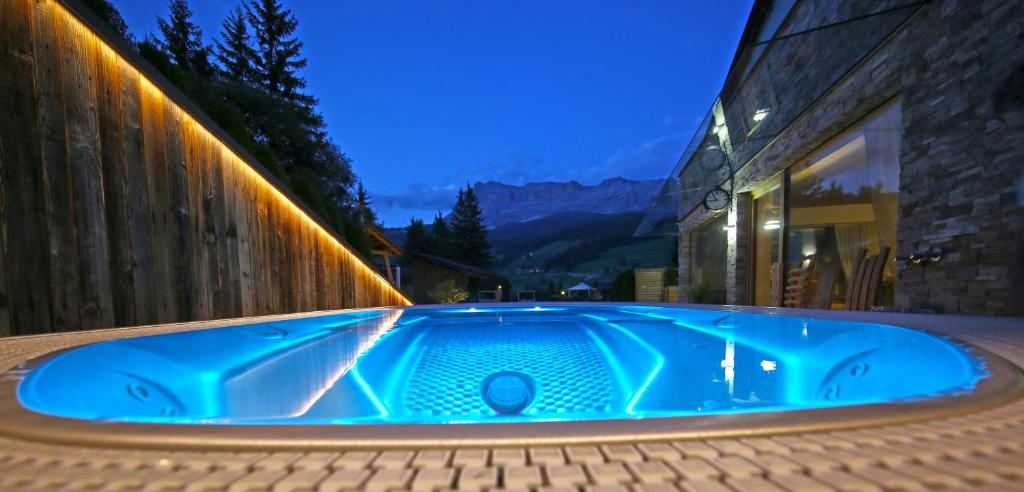 bañera de hidromasaje azul frente a un edificio en La Bercia Dolomites Chalet, en La Villa
