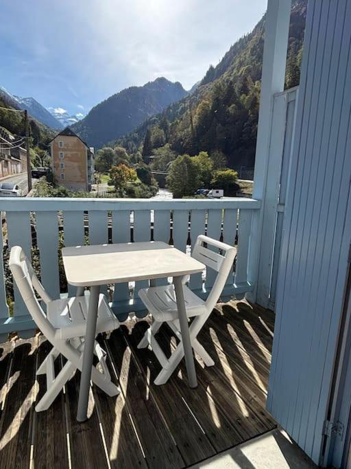 d'une table et de chaises blanches sur un balcon avec vue sur la montagne. dans l'établissement Charmant T2bis, belle vue centre, à Cauterets
