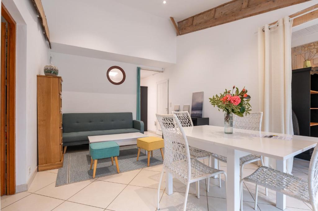 a living room with a white table and chairs at Petit appartement in Saint-Gildas-de-Rhuys