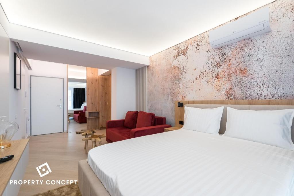 a bedroom with a white bed and a red chair at Cortina Concept Studio 128 in Voluntari