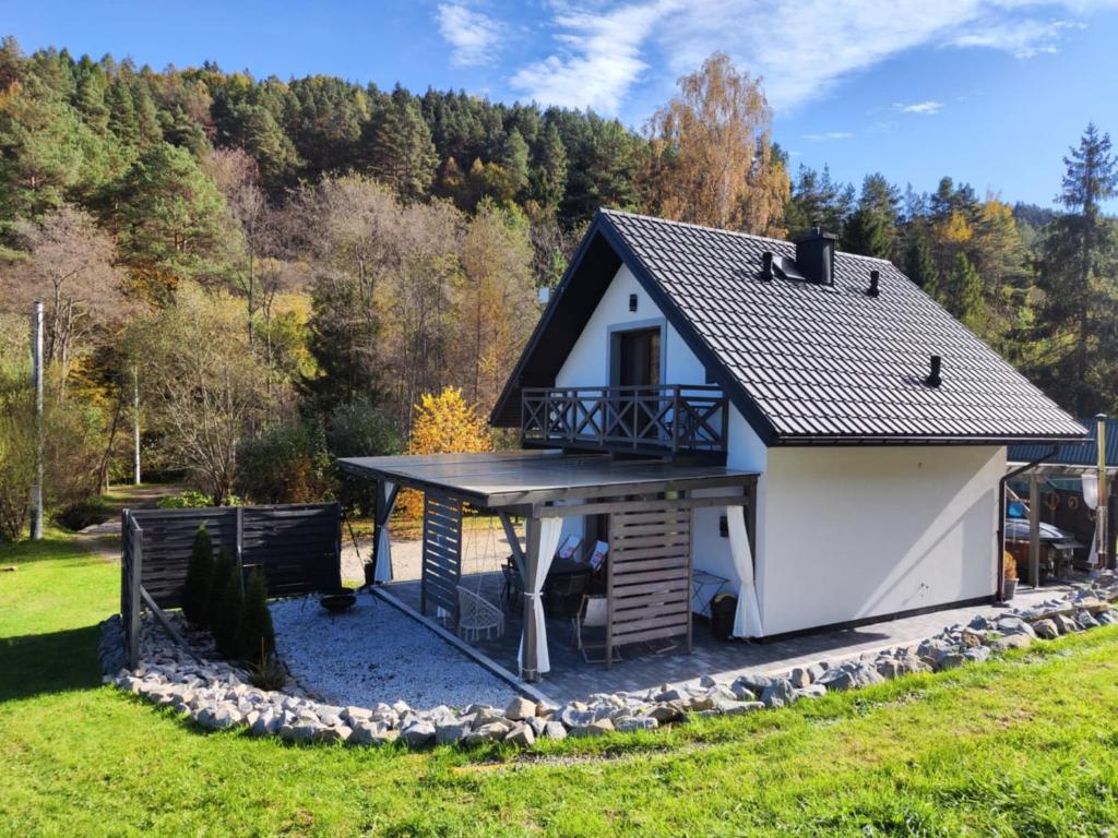 a tiny house with a porch and a deck at Leśny Zaułek in Muszyna
