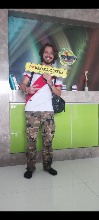a man holding a sign that reads kaagi appliances at WakakaPackers in Kuala Lumpur