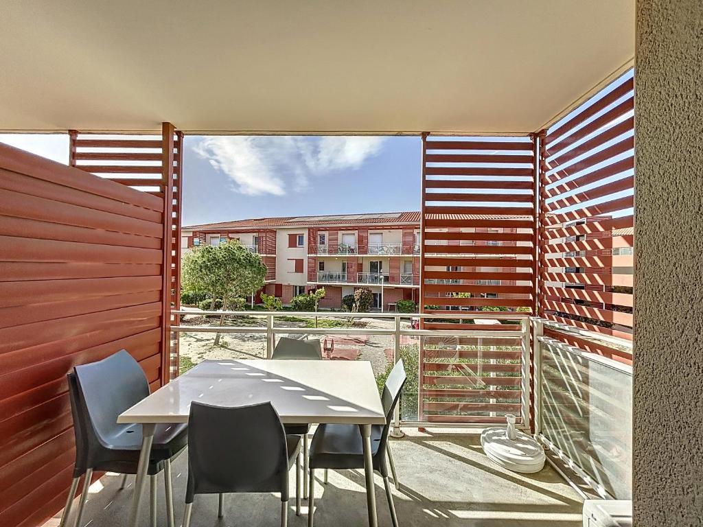 d'un balcon avec une table et des chaises et une vue sur un bâtiment. dans l'établissement 3309-T3 dans une résidence avec piscine, à Argelès-sur-Mer