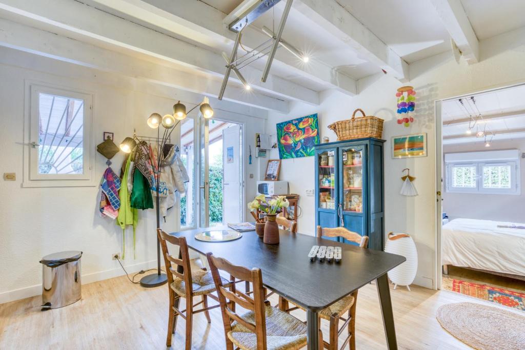 - une salle à manger avec une table, des chaises et un lit dans l'établissement Maison pour 6 entre Vignes et Mer, à Marseillan