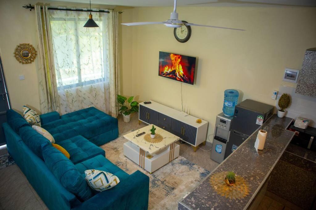 a living room with a blue couch and a table at Derosa Homes Figtree Apartment 2bdrm in Tezo