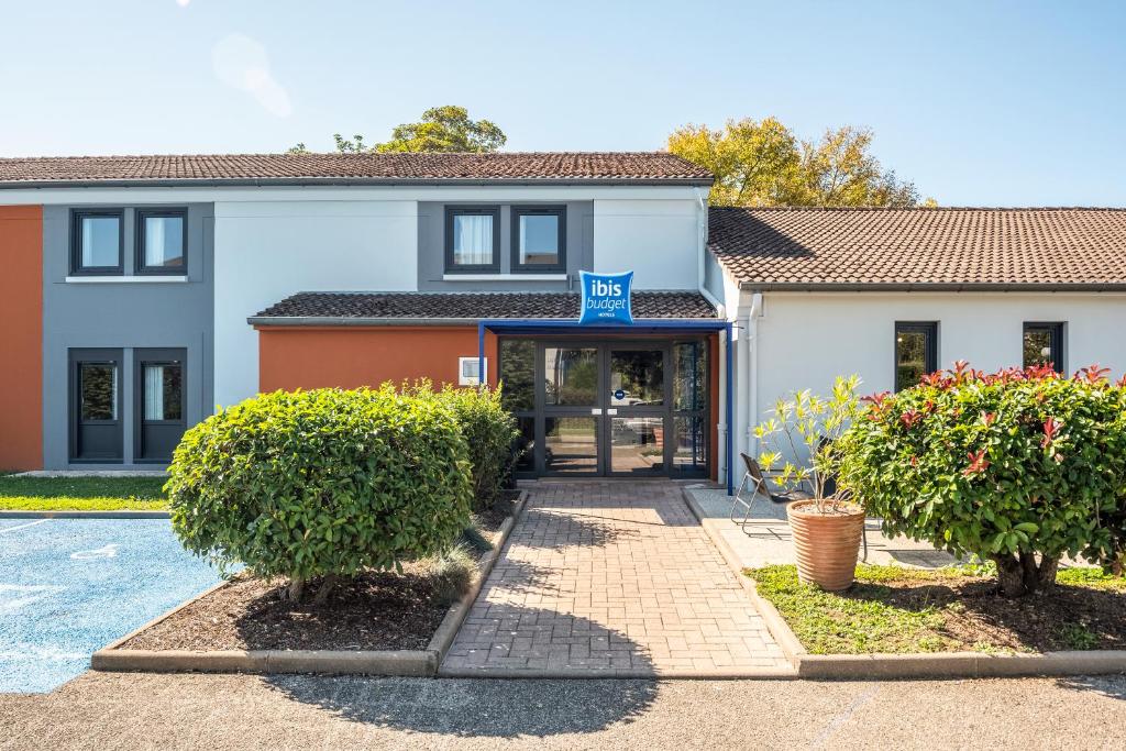 un bâtiment avec un panneau indiquant motel dans l'établissement Ibis Budget Villefranche, à Limas