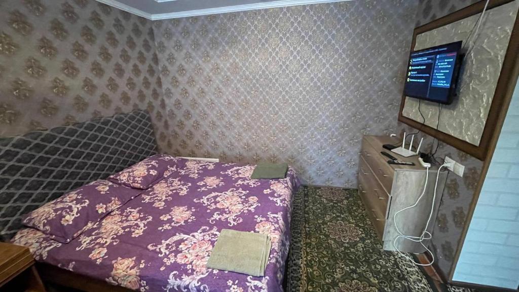 Un dormitorio pequeño con una cama y un televisor. en Eles2, en Karakol