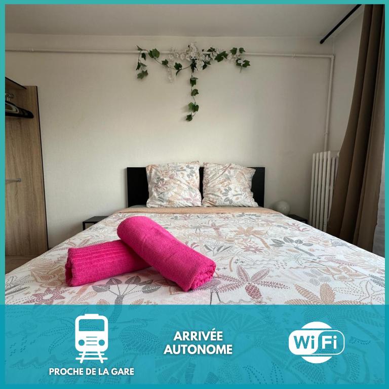 une chambre avec un lit avec des serviettes roses dessus dans l'établissement Le Jules Verne, proche de la Gare, à Boulogne-sur-Mer