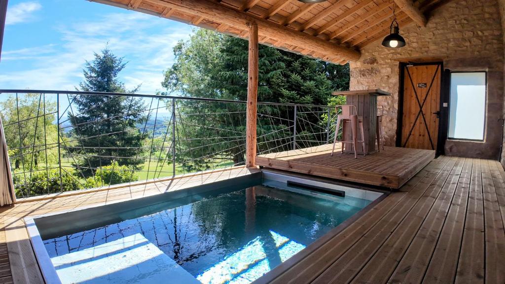 - une piscine sur une terrasse avec un balcon dans l'établissement Les Fermes de Manat gîte romantique avec piscine balnéo et sauna, à Luriecq