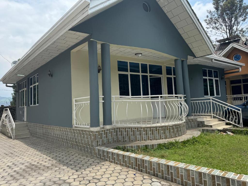 una casa azul con porche y escaleras en Mont Goma, en Goma