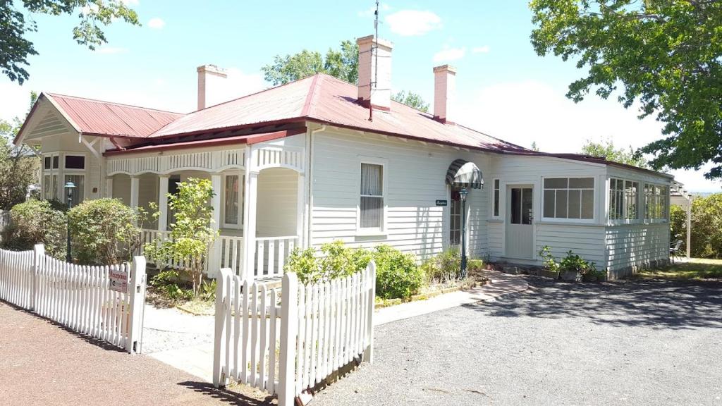 a white house with a white fence in front of it at Ross B&B Accommodation in Ross