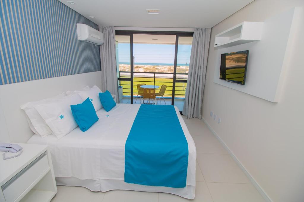 una camera da letto con un letto e vista sull'oceano di Stúdios Ponta dos Molhes a Torres