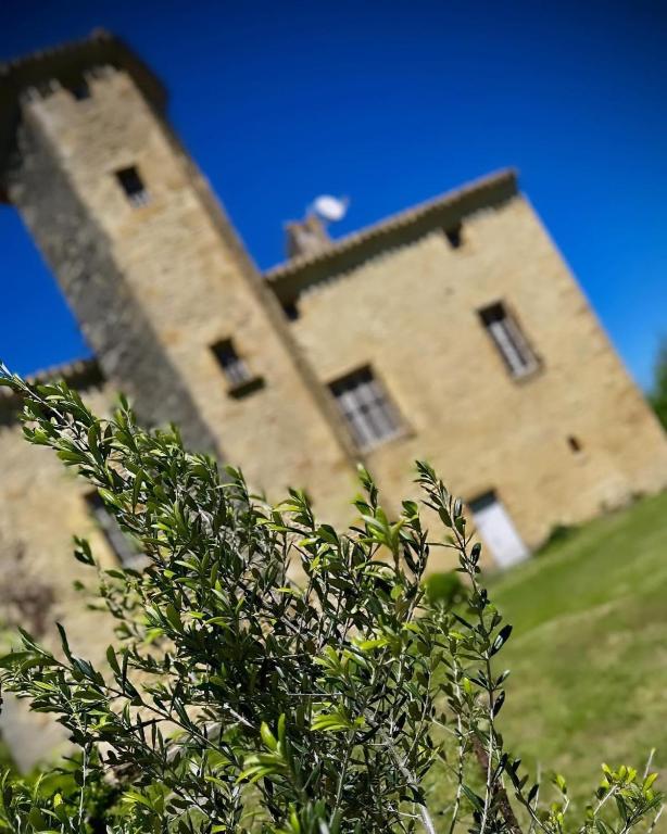 un grand bâtiment en briques au sommet d'une colline dans l'établissement Le Domaine de Pépé, à Saint-Julien-de-Briola