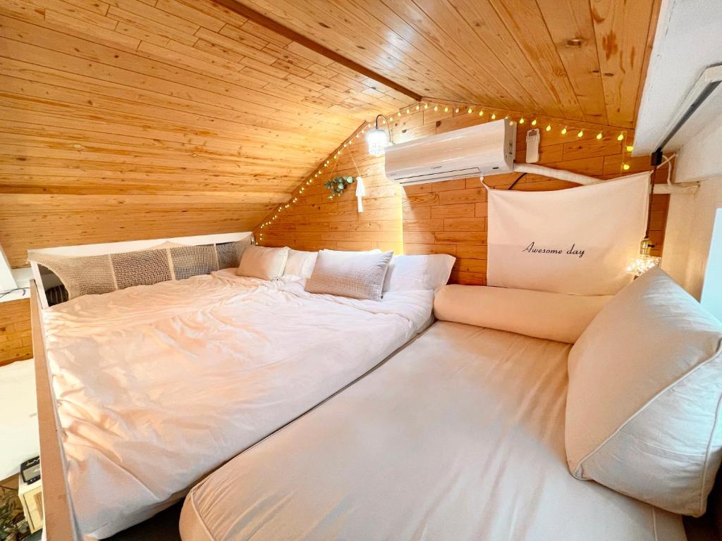 ein Zimmer mit 2 Betten in einem kleinen Zimmer in der Unterkunft 3min from Metro - Lodging with roof terrace - Convenient transport - CVS downstairs - Hot places nearby in Seoul