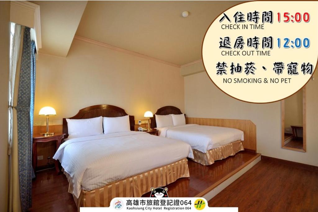 a hotel room with two beds and a sign at Goodness Hotel in Kaohsiung