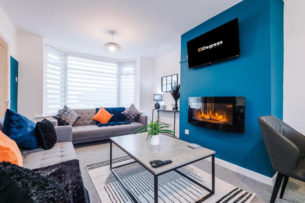 a living room with a blue wall with a fireplace at NEW! 3-Bed Home in Manchester by 53 Degrees Property, Ideal for Contractors & Business Stays, Sleeps 8! in Manchester