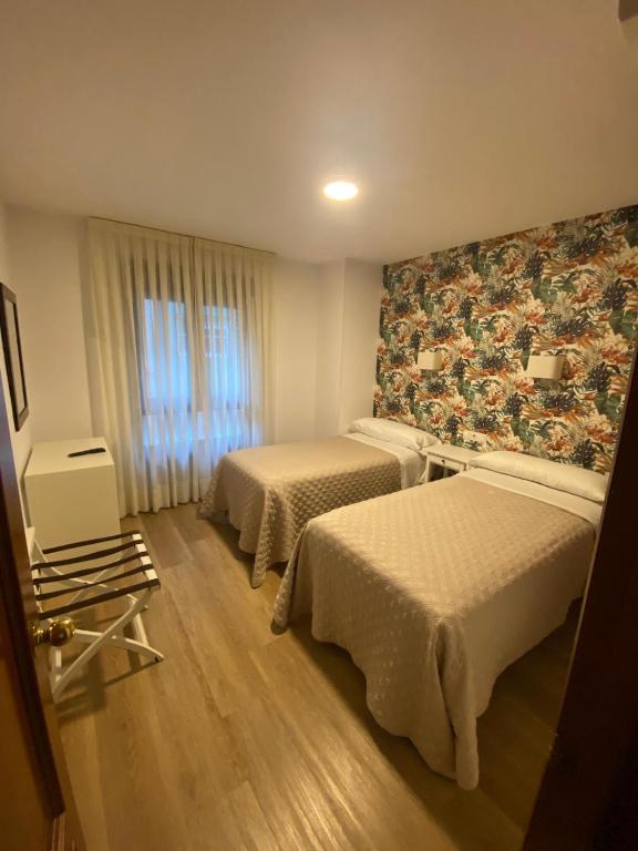 A bed or beds in a room at Hotel Ovetense