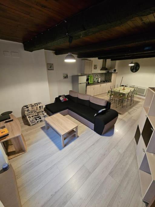 un salon avec un canapé et une table dans l'établissement Maison de village dans hameau calme, à Dio-et-Valquières
