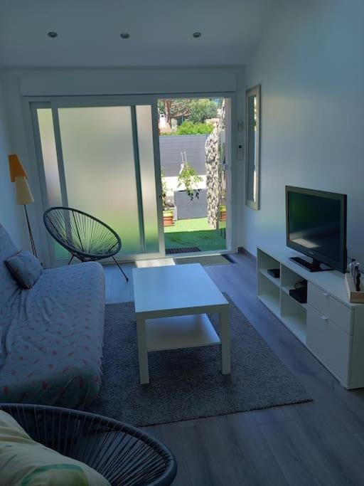 un salon avec un canapé, une table et une télévision dans l'établissement chez Marie, à Villeneuve-Loubet