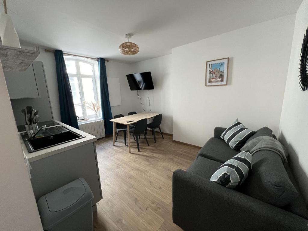 Il comprend un salon avec un canapé, une cuisine et une table. dans l'établissement Oasis Urbaine - 2-4p centre-ville, Place Dalton, à Boulogne-sur-Mer