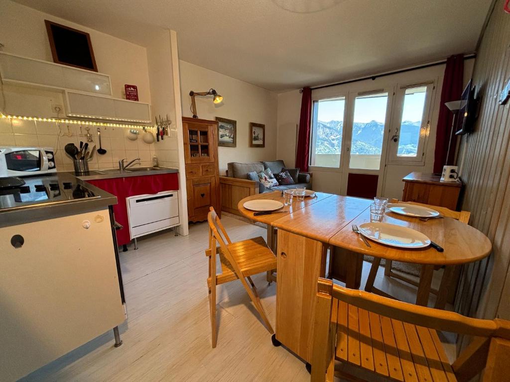 een keuken met een grote houten tafel in een kamer bij Résidence Grand Bois A310 Clés Blanches in La Tania